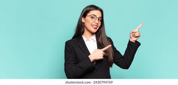 young pretty woman feeling joyful and surprised, smiling with a shocked expression and pointing to the side. business concept - Powered by Shutterstock