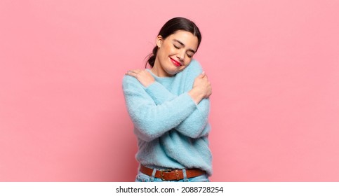 young pretty woman feeling in love, smiling, cuddling and hugging self, staying single, being selfish and egocentric - Shutterstock ID 2088728254