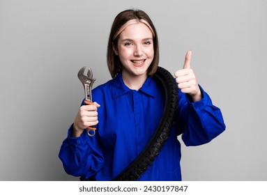 young pretty woman feeling proud,smiling positively with thumbs up. bike mechanic concept - Powered by Shutterstock