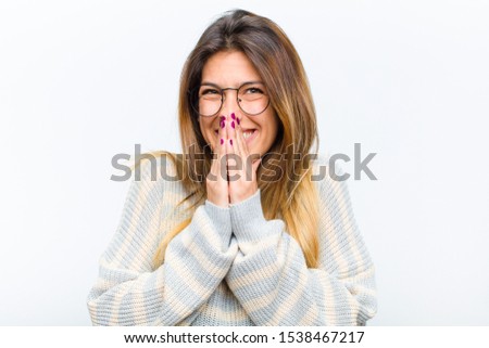 young pretty woman happy and excited, surprised and amazed covering mouth with hands, giggling with a cute expression against white background Foto d'archivio © 