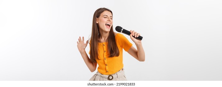 Young pretty woman happy and motivated, singing a song with a microphone, presenting an event or having a party, enjoy the moment - Shutterstock ID 2199021833