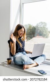 Young Pretty Woman Have Video Call On Laptop From Home Office Workplace On The Windowsill. Concept Of Female Business, Career, Online Shopping.