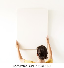 Young pretty woman hold blank canvas and empty mockup copy space  Minimal art concept 