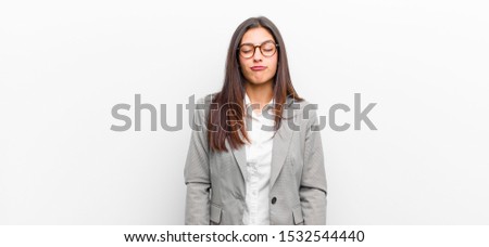 young pretty woman looking goofy and funny with a silly cross-eyed expression, joking and fooling around isolated against white wall