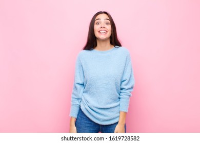 Young Pretty Woman Looking Happy And Goofy With A Broad, Fun, Loony Smile And Eyes Wide Open Against Pink Wall
