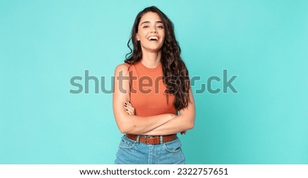 young pretty woman looking like a happy, proud and satisfied achiever smiling with arms crossed