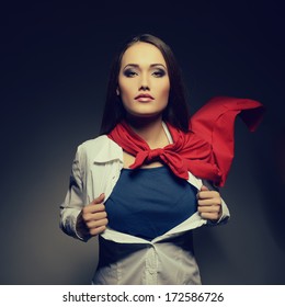 Young pretty woman opening her shirt like a superhero. Super girl, image toned. Beauty saves the world. - Shutterstock ID 172586726