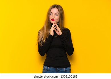 Young pretty woman over yellow background scheming something