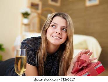 young pretty woman with present at home alone - Shutterstock ID 71265517