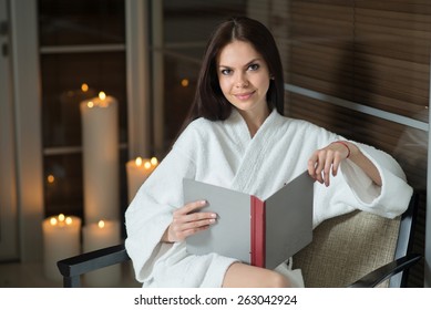 Young Pretty Woman Reading Menu In The Restroom At The Hotel Spa