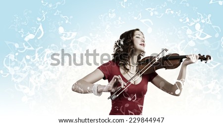 Young pretty woman in red dress playing violin