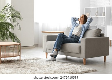 Young pretty woman resting on couch at home - Powered by Shutterstock