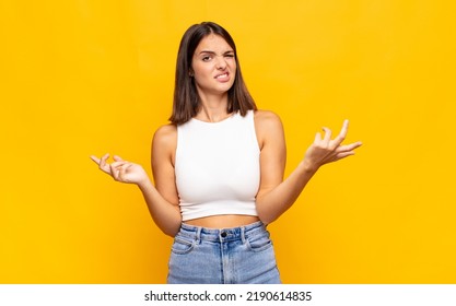 young pretty woman shrugging with a dumb, crazy, confused, puzzled expression, feeling annoyed and clueless - Shutterstock ID 2190614835