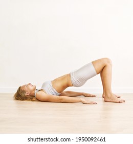 Young Pretty Woman Standing In Pelvic Brigde. Yoga Exercise At Gym. Home Sport Workout. Elbows Static Balance Stand. Floor Stretching. Healthy Lifestyle. Long Blond Hair. Smiling Female Person. Side