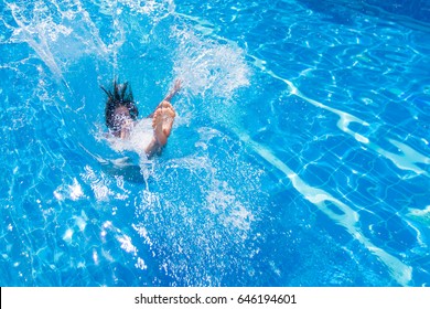 Young Pretty Woman In Swimsuit Jumping Into The Pool With A Splash