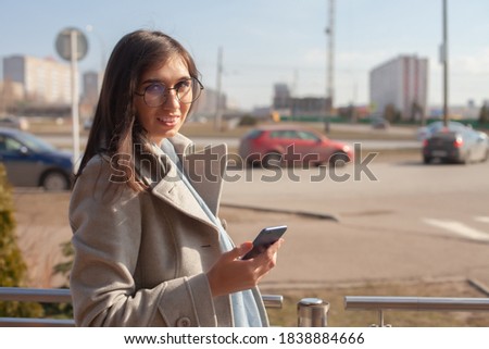 Young pretty woman talking at cellular phone in street