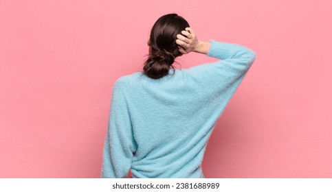 young pretty woman thinking or doubting, scratching head, feeling puzzled and confused, back or rear view - Powered by Shutterstock