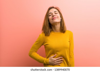 Young pretty young woman touches tummy, smiles gently, eating and satisfaction concept. - Shutterstock ID 1389940070