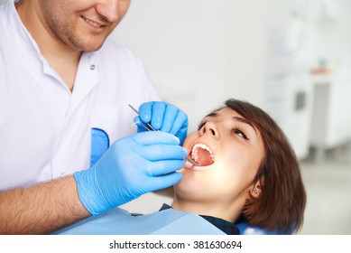 Young pretty woman treating tooth caries in dental clinic. Concept of teeth hygiene, whitening and perfect smile.  