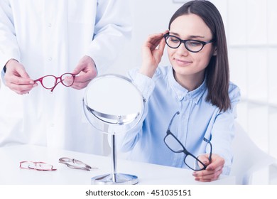 Young Pretty Woman With Vision Defect On Optician's Consultation. Trying New Corrective Glasses