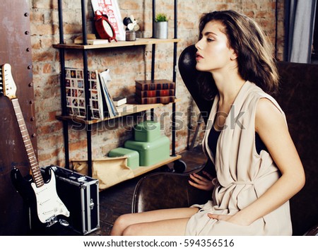 young pretty woman waiting alone in modern loft studio, fashion musician concept, lifestyle people