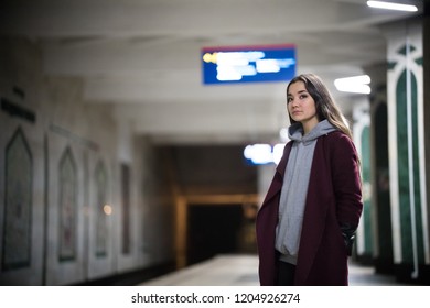 Young Pretty Woman Waiting For The Train In Subway Platform.