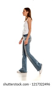 Young Pretty Woman Walking In Bell Bottom Jeans On White Background