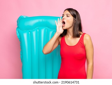 Young Pretty Woman Yelling Loudly And Angrily To Copy Space On The Side, With Hand Next To Mouth