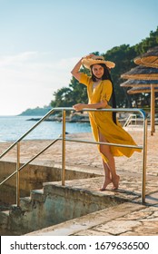 Young Pretty Woman In Yellow Sundress At Sea Beach