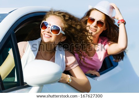 Young pretty women leaning out of car window