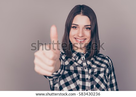Young pretty women showing thumb up gesture against gray background