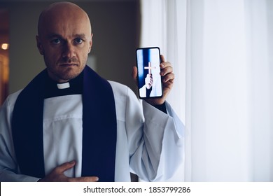 Young Priest Holding A Mobile Phone.