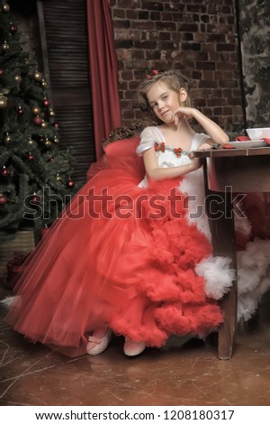 young princess in a red and white dress sitting by the table