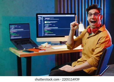 Young Proactive Insighted Software Engineer IT Specialist Programmer Man In Shirt Work At Home Writing Code On Laptop Pc Computer Hold Index Finger Up With Great New Idea. Program Development Concept