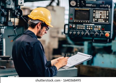 Young Profession Technician Engineer Operate Heavy Machine To Automated CNC In Factory, Worker With Check List.