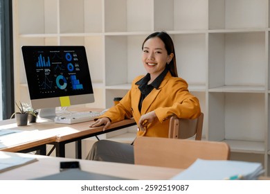 Young professional analyzing data and statistics on desktop computer, showcasing expertise in business and finance