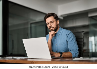 Young professional busy business man executive leader using laptop working in office, busy ceo businessman software engineer thinking looking at computer analyzing online financial market at work.