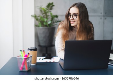 Young Professional Doing Creative Project On Laptop. Girl Sitting By Computer At Office Desk. Digital Tools And Solutions For Business And Education, Distant Webinars, Lectures, Workshops, Courses.