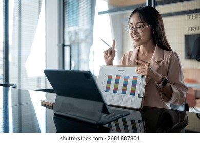 Young professional explaining charts and graphs during an online meeting, working remotely