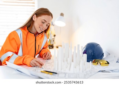 Young professional female architect reviews building plans and model during a creative work session in office	 - Powered by Shutterstock