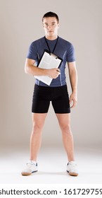 Young Professional Fitness Coach Standing In Studio