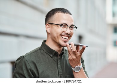 Young, Professional And Happy Businessman Using A Phone Outdoors. Positive Male Smiling While Speaking On A Call. Handsome Guy Standing Alone Outside While Using Technology To Communicate With