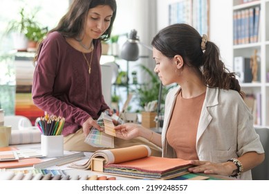 Young professional interior designers and decorator working on a project: they are checking swatches and choosing the perfect color palette, creativity concept - Powered by Shutterstock