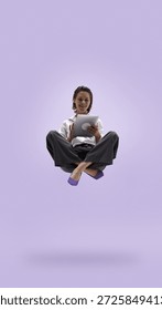 Young professional levitating while using tablet in office style. Concept of mobile workflow, task flexibility, mobile productivity, flexible schedule and stress free business lifestyle.