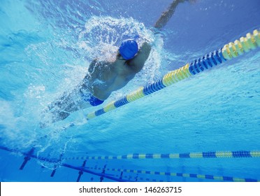 Young professional male athlete doing backstroke in swimming pool - Powered by Shutterstock
