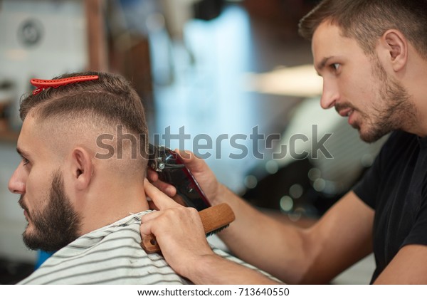 Young Professional Male Barber Concentrating While Stock Photo