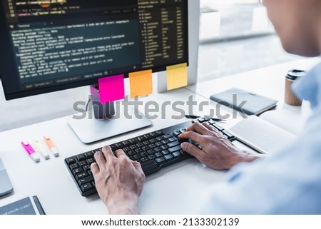 Young Professional programmer working at developing programming and website working in a software develop company office, writing codes and typing data code, Programming with HTML, PHP and javascript.