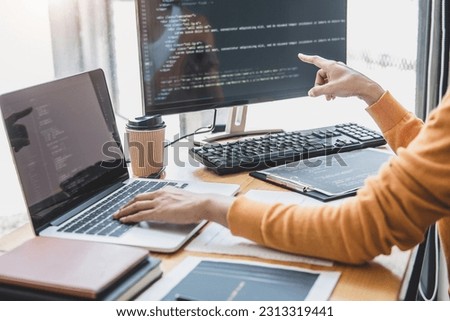 Young Professional programmer working at developing programming and website working in a software develop company office, writing codes and typing data code, Programming with HTML, PHP and javascript.