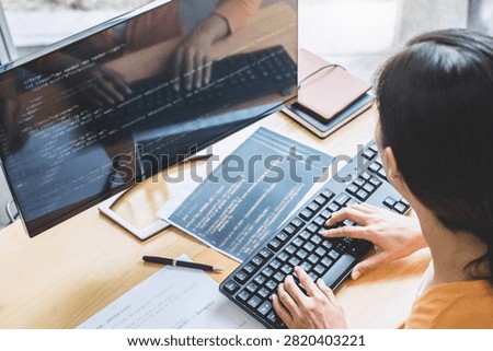Young Professional programmer working at developing programming and website working in a software develop company office, writing codes and typing data code, Programming with HTML, PHP and javascript.