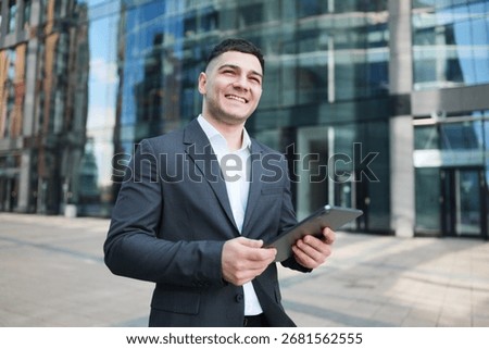 Young professional smiles while using tablet in urban business district